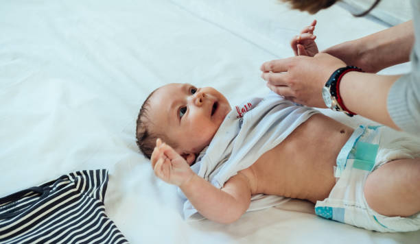 istock Mother Dressing Up Little Baby in Bed 1316832897