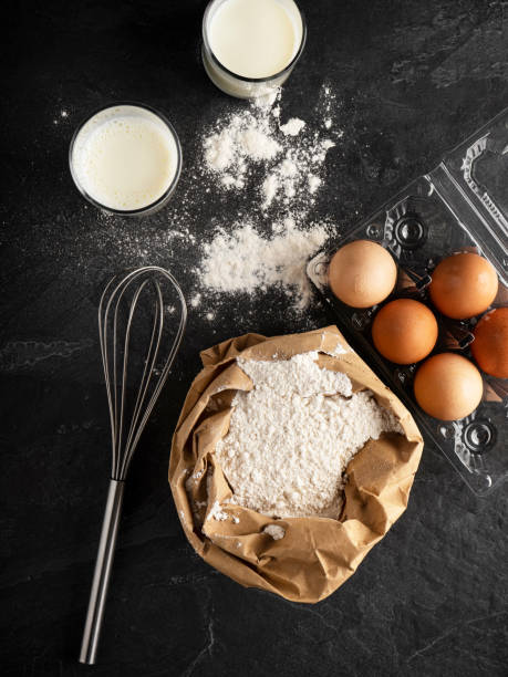farina di grano in sacchetto di carta, farina con uova e latte, pasta che fa ingredienti e utensili con spazio, - baking flour ingredient animal egg foto e immagini stock