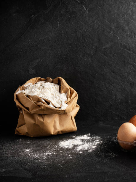 farina di frumento in sacchetto di carta, farina con uova, - baking flour ingredient animal egg foto e immagini stock