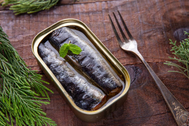 istock Tin of sardines with Mentha spicata on a rustic table. 1316834877