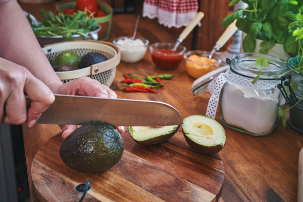 istock Cutting Avocado on Wooden Cutting Board 1316835619