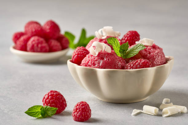 sorbet framboise . crème glacée de baies dans le bol avec des framboises de frech et le chocolat blanc. fermez-vous vers le haut - raspberry ice cream close up fruit mint photos et images de collection