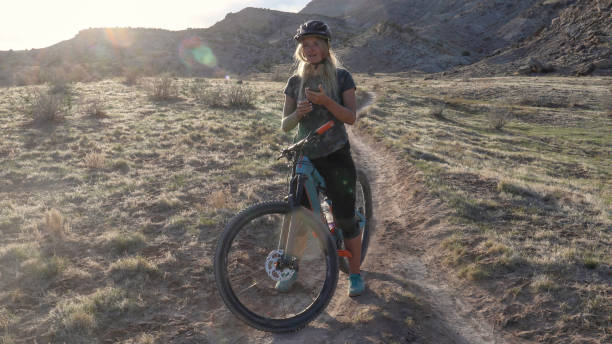 istock Female mountain biker rides along forked trail 1316838359