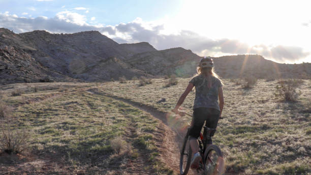 istock Female mountain biker rides along desert trail 1316838405