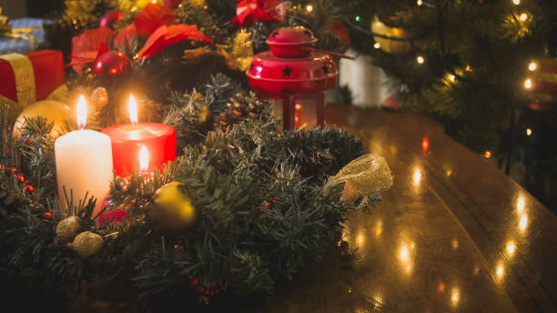 istock Advent wreatch on table with burning candles next to decorated Christmas tree 1316840890
