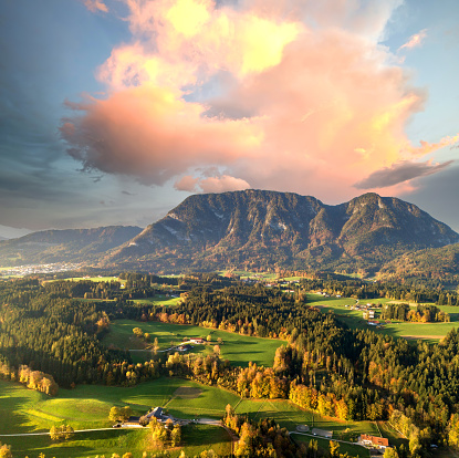 Aerial view of green meadows with villages and forest in austrian Alps mountains.