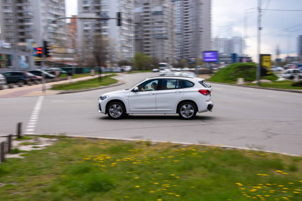 biały samochód bmw x1 poruszający się po ulicy. - bell zdjęcia i obrazy z banku zdjęć