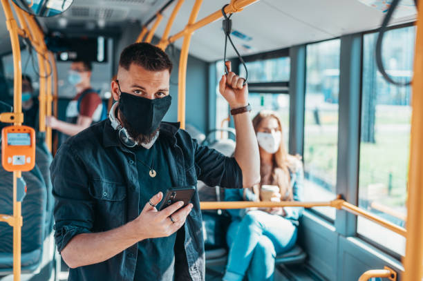istock Handsome man wearing face protective mask and using a smartphone in a bus 1316853898