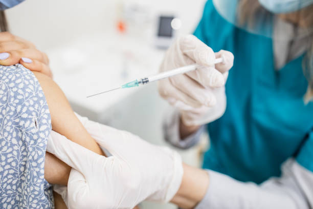 istock Doctor in a protective workwear giving a shot of vaccine 1316856486