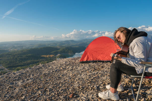 istock Handsome man playing guitar on mountain peak 1316859690