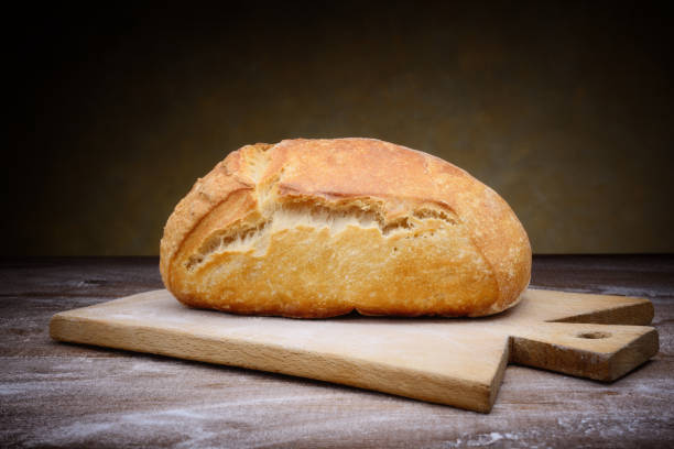 istock Fresh bread, bun and cutting board on wooden table, copy space. 1316864274
