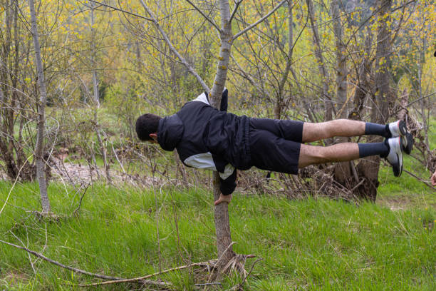 istock Young athlete doing an exercise routine called the flag in a tree in a natural environment of the countryside with selective focus concept exercise in nature. 1316865083