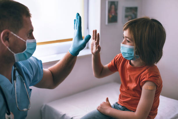 Happy little child giving high-five to the doctor after Covid-19 vaccination Happy little child giving high-five to the doctor after Covid-19 vaccination. Hope concept. adhesive bandage photos stock pictures, royalty-free photos & images