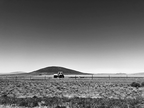Ute Mountain New Mexico with tractor. Ute Mountain is a volcanic cone in northern New Mexico and the highest point of the Rio Grande del Norte National Monument. Copy space in the sky.