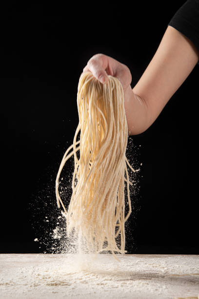 istock Hand holding noodle Studio shot on black background 1316875961