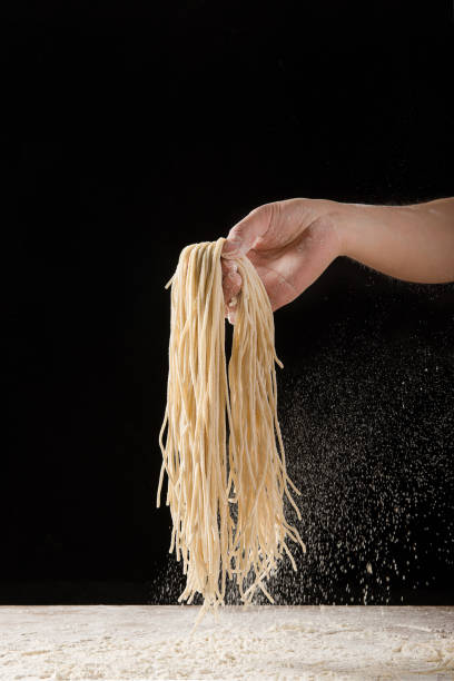 istock Hand holding noodle Studio shot on black background 1316876661