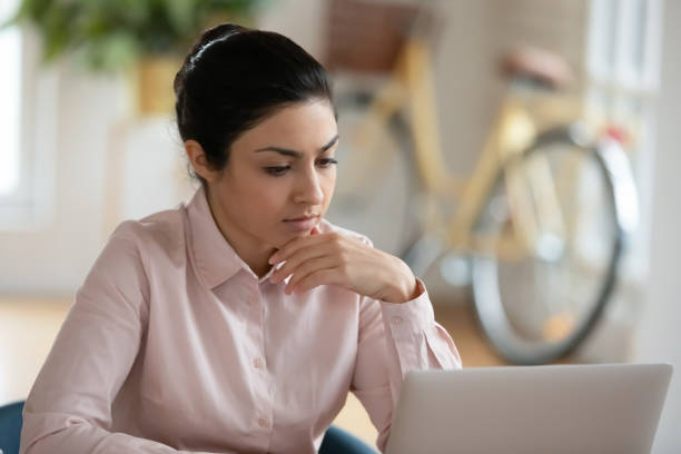 istock Serious young Indian woman working at computer at home 1316877988