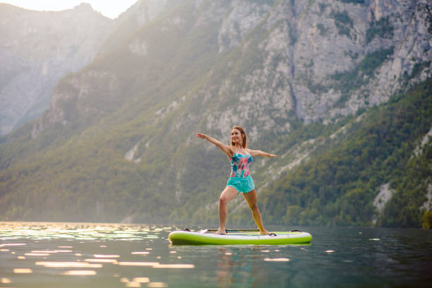 istock Woman in Early 30s Doing Warrior II Yoga Pose on Paddleboard 1316878149