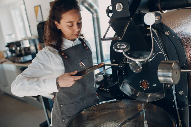 istock Coffee roaster machine and barista with tryer at coffee roasting process 1316878234