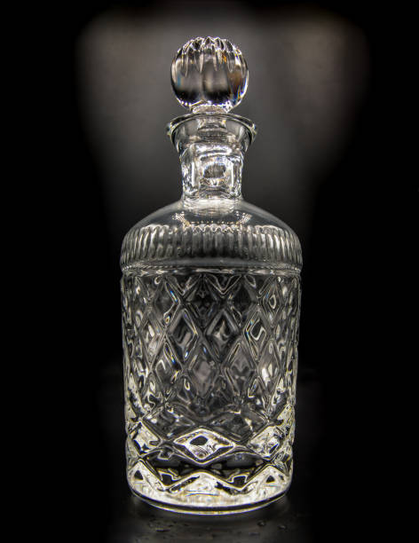 empty crystal decanter with engraving, closed with a glass stopper on black background. - decanter crystal carafe glass imagens e fotografias de stock