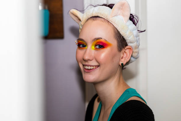 istock Teenage girl smiles at camera while applying makeup 1316886661