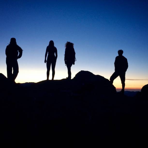 istock Silhouette of hikers atop a mountain range. 1316886776