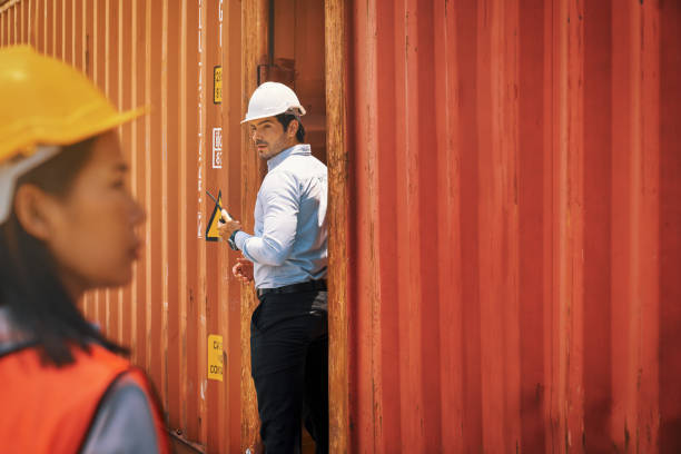 istock Foreman looking to assistance women at cargo site container between 2 red boxes 1316895864
