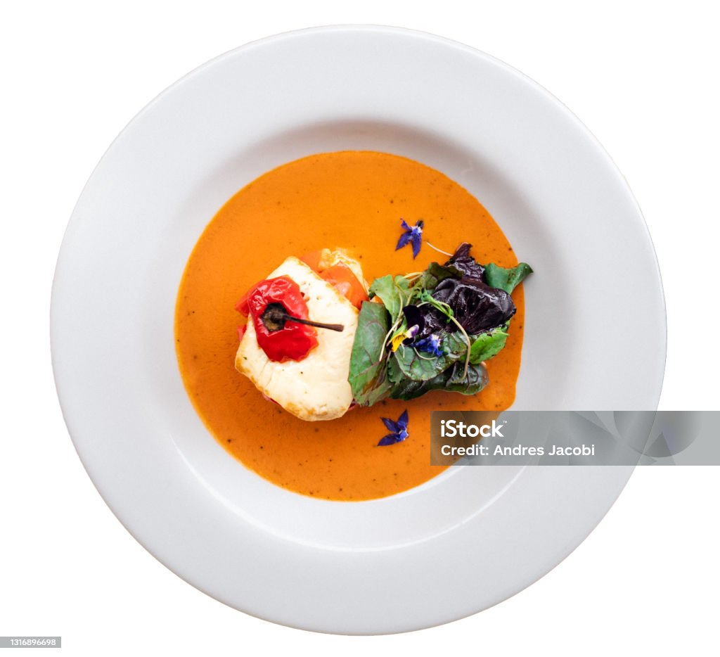 Delicious stuffed pepper with a juicy sauce and a fresh green salad. Served on a white plate Delicious stuffed pepper with a juicy sauce and a fresh green salad. Served on a white plate. Top view, white background Cut Out Stock Photo