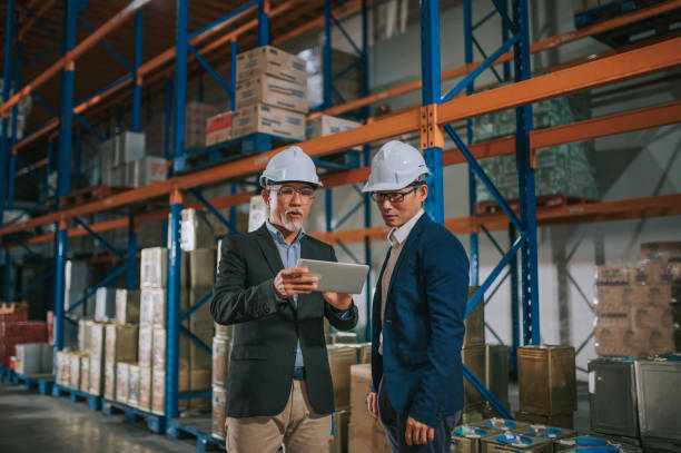 istock asian chinese management having discussion at warehouse with white hardhat using digital tablet 1316897126