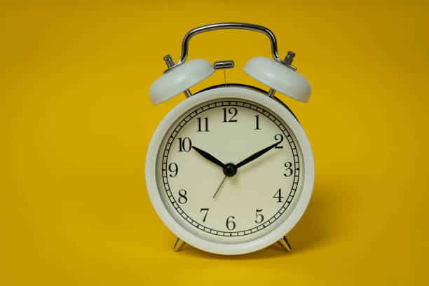 istock Retro alarm clock on yellow background. Old fashioned alarm clock 1316899327