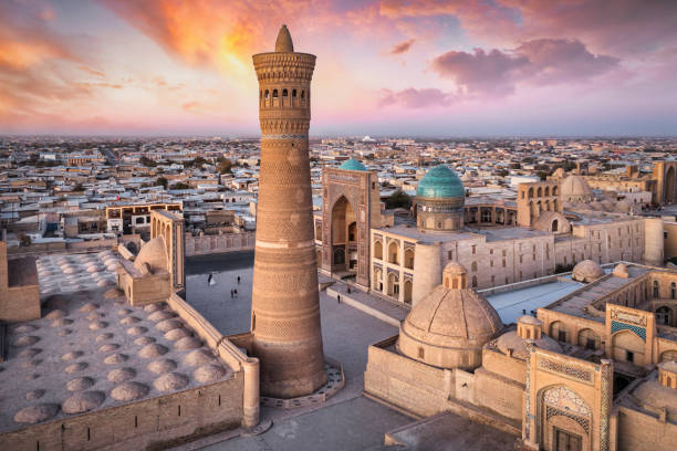 Bukhara Uzbekistan Kalyan Minaret and Madressa Sunset Twilight Colorful sunset twilight over the famous old town in the City of Bukhara with the iconic Kalyan Minaret and Mir-i-Arab Madressa. Aerial Drone Point of View. Itchan Kala, Bukhara, Khorezm Region, Uzbekistan, Central Asia. minaret stock pictures, royalty-free photos & images