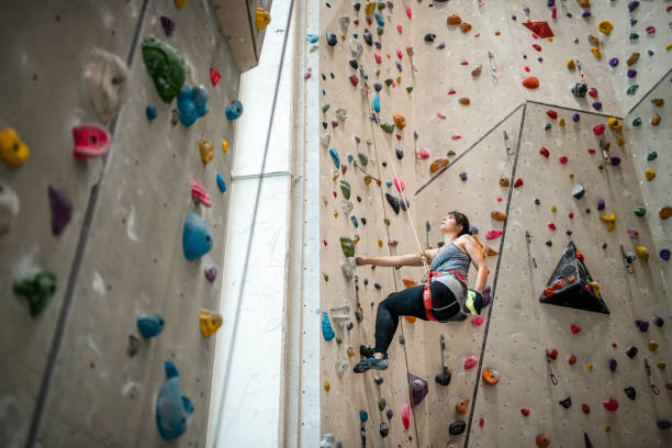 istock Sportswoman Suspended by Rope While Scaling Climbing Wall 1316903527