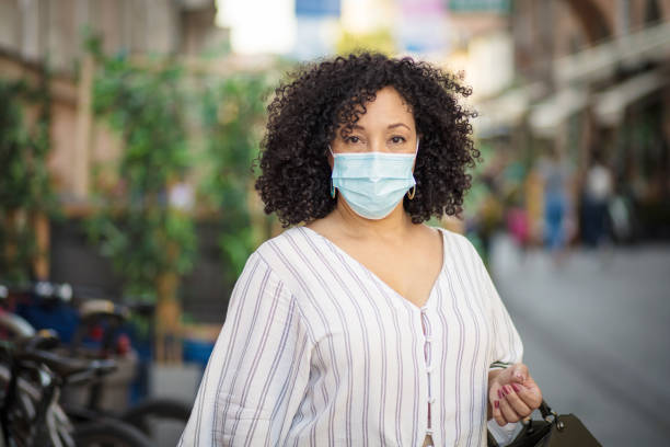 istock Woman with protective mask on face walking trough city. 1316905476