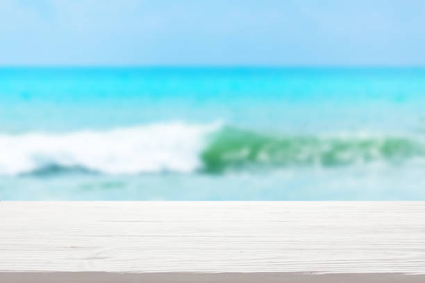 istock white wood table top on blur sea wave background 1316905750
