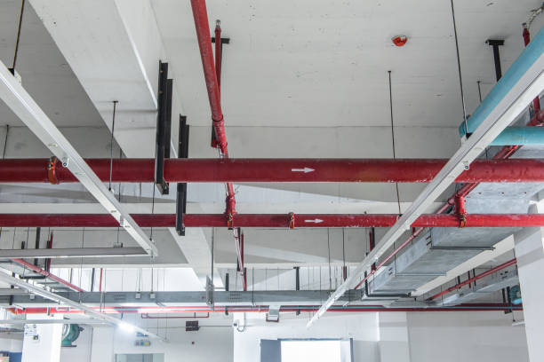 Fire protection sprinkler system with red pipes is placed to hanging from the ceiling Fire protection sprinkler system with red pipes is placed to hanging from the ceiling exploitation stock pictures, royalty-free photos & images