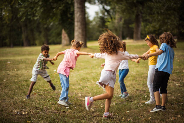 grand groupe d’enfants d’école ayant l’amusement dans la nature. - smiling little girls little boys autumn photos et images de collection