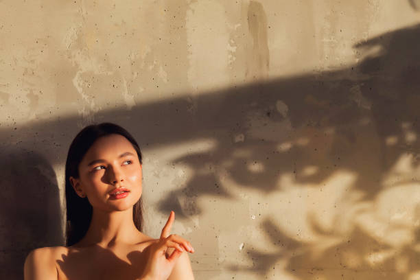 verticale de jeune femme gaie mignonne montre le doigt - young old studio skin photos et images de collection