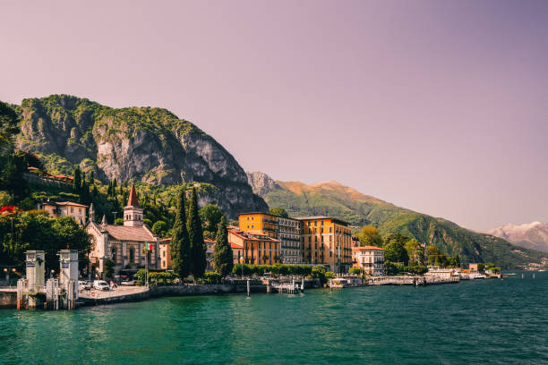 Beautiful Cadenabbia, Como lake, Italy Blue peaceful Como lake (Lago di Como) in sunny evening, Cadenabbia, Northern Italy scene. Expensive tourist destination and holiday. Forest and hills, gorgeous harbour, old embankment with boat pier como italy photos stock pictures, royalty-free photos & images
