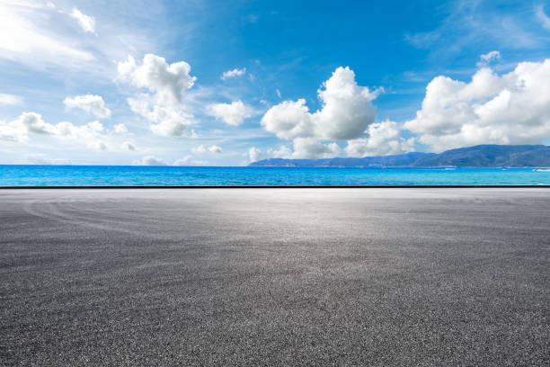 leere asphaltstraße und meereslandschaft. - season lake cloudscape horizon stock-fotos und bilder