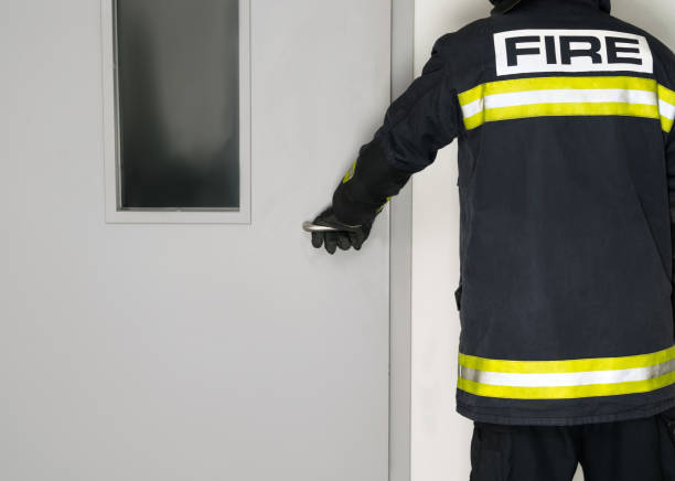 istock a man in a fireman's uniform opens the door, rear view 1316913923