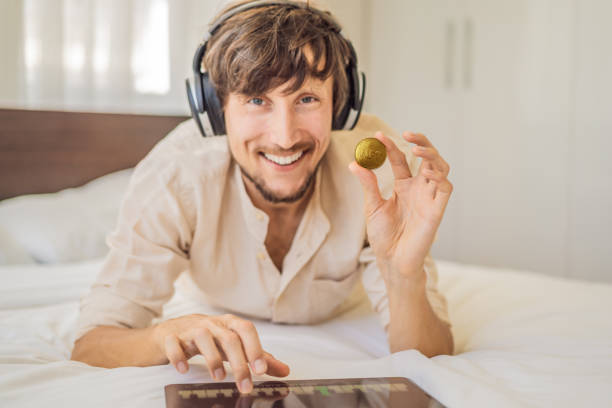 jeune homme, artiste numérique, dj crée de l’art numérique sur une tablette à la maison et montre une pièce avec l’inscription ntf - jeton non fongible. travail à distance, nomade numérique, peinture numérique, animation, vidéo - newspaper the media digital tablet digitally generated image photos et images de collection