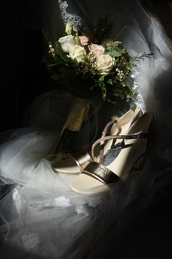 Wedding bouquet and wedding shoes on bridal veil