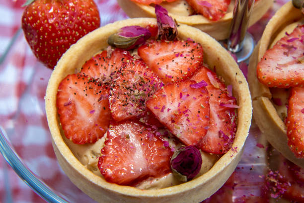 istock A strawberry tart topped with red flower on a kitchen table cover 1316917509