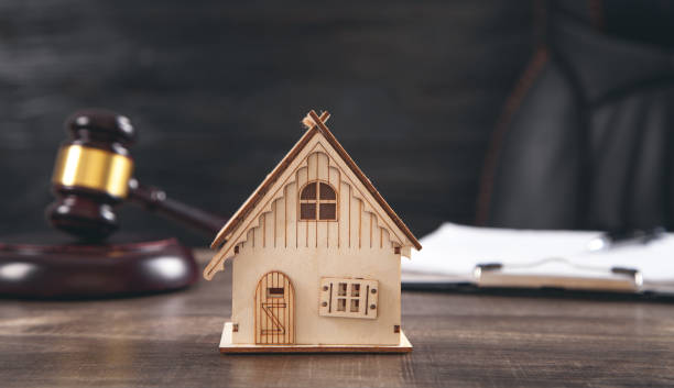 istock Judge gavel, house model and document on the table. 1316921479