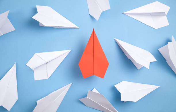 istock Red and white paper airplanes on blue background. Leadership. Teamwork 1316921560