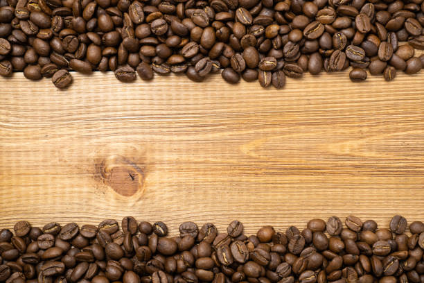 istock Scattered coffee beans on wooden background with copy space. 1316921644