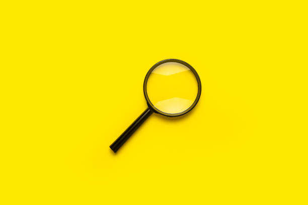 istock magnifying glass loupe search symbol on yellow background with copy space. 1316924476