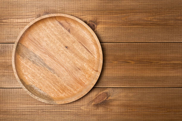 istock Round blank wooden plate on wooden table, top view. Mock up template. 1316930847