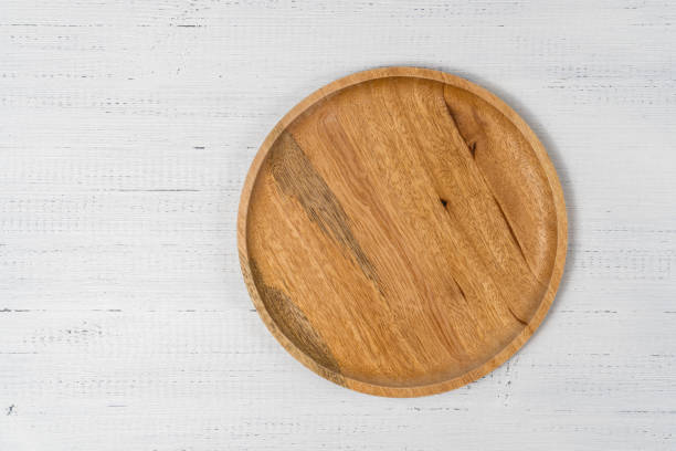 istock Round wooden plate on white wood background, top view. 1316930852