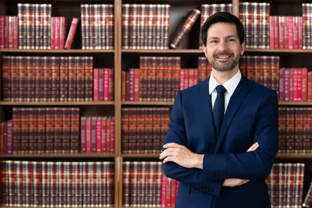 Male Attorney With Arms Crossed. Lawyer In Office